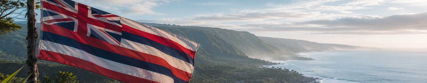 Morning view of the Hamakua Coast with a Hawaiian flag overlooking lush cliffs and the Pacific Ocean